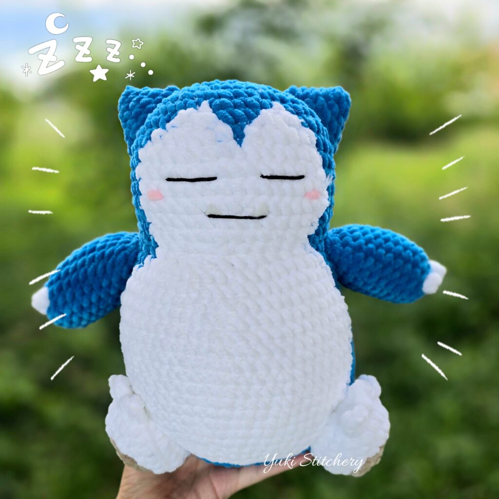 Crochet snorlax plush doll with eyes closed.